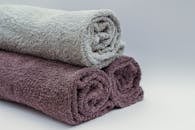 Close-up of rolled bathroom towels in neutral tones, ideal for interior design or spa themes.